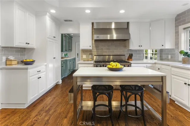 a kitchen with a table chairs sink and cabinets