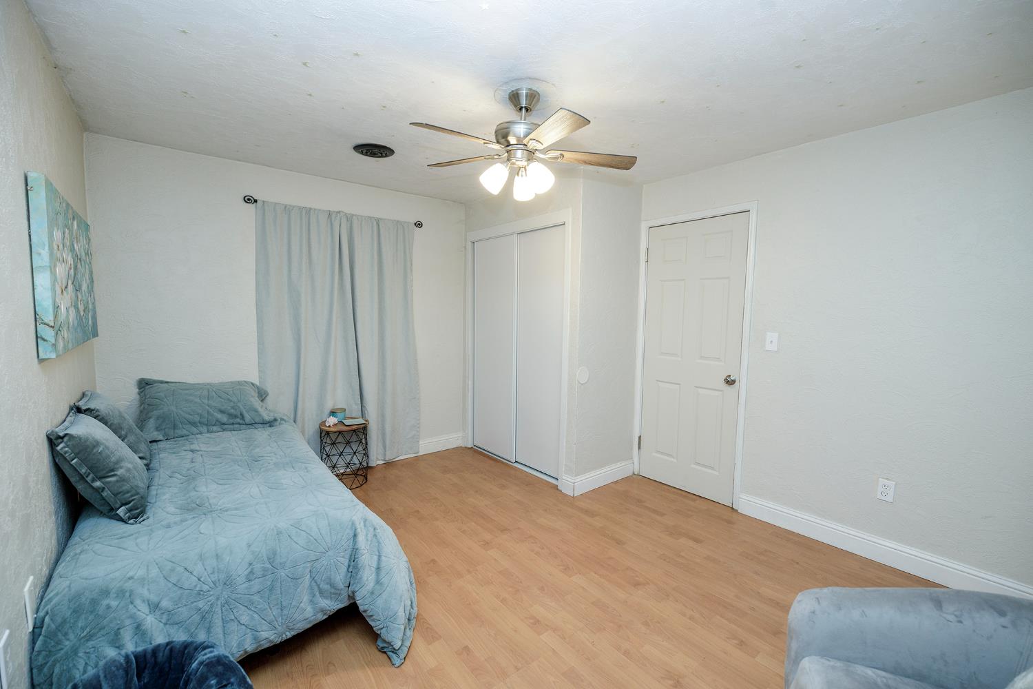 1244 Melrose Avenue Modesto, CA 95350 - Photo 22 of 39 a bedroom with a large bed and a chandelier fan