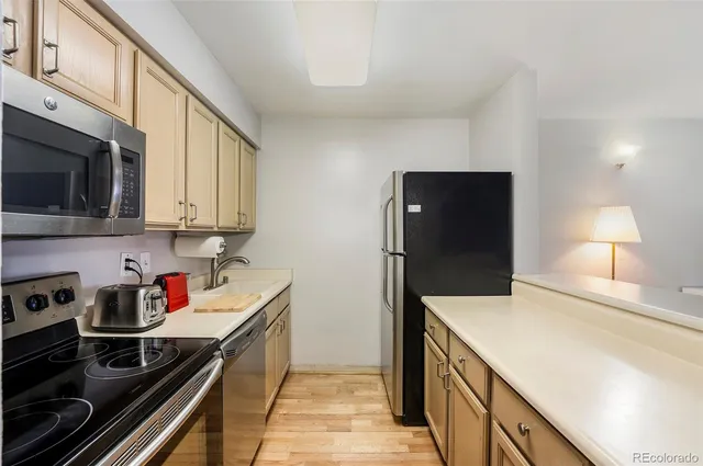 a kitchen with stainless steel appliances a stove a sink and a refrigerator