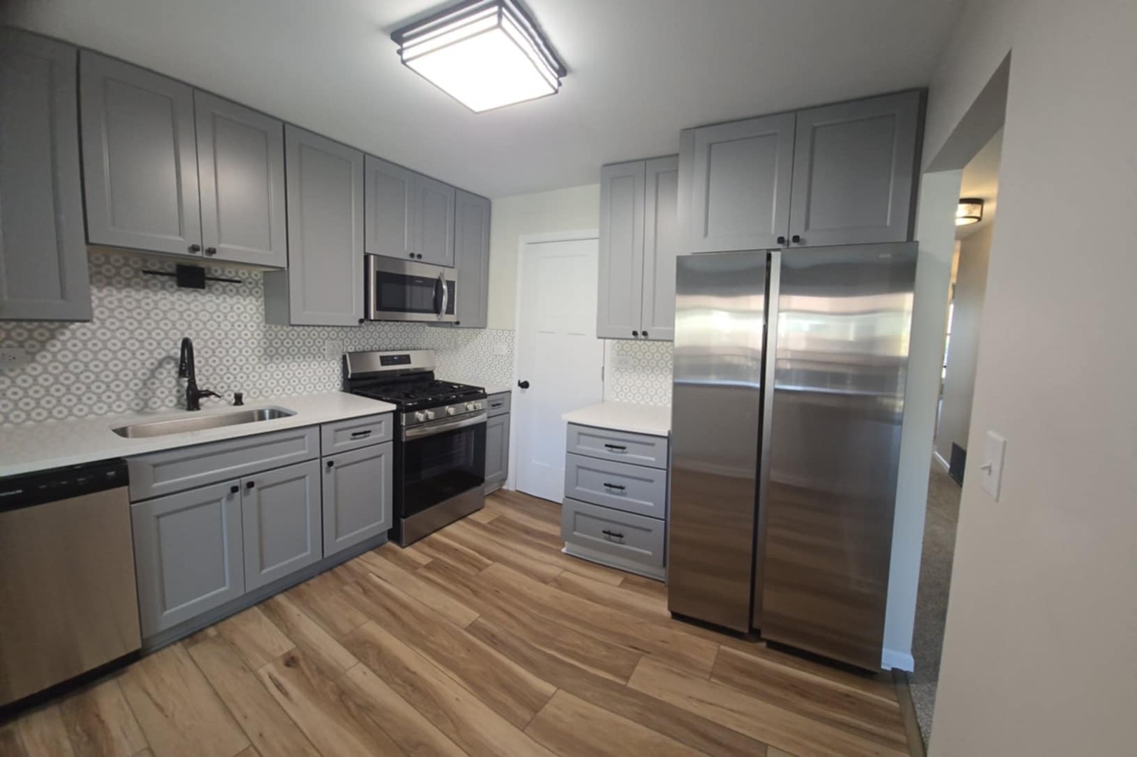 2860 Northampton Drive, Unit B2 Rolling Meadows, IL 60008 - Photo 5 of 22 a kitchen with stainless steel appliances granite countertop a refrigerator a sink dishwasher a stove and white countertops with wooden floor