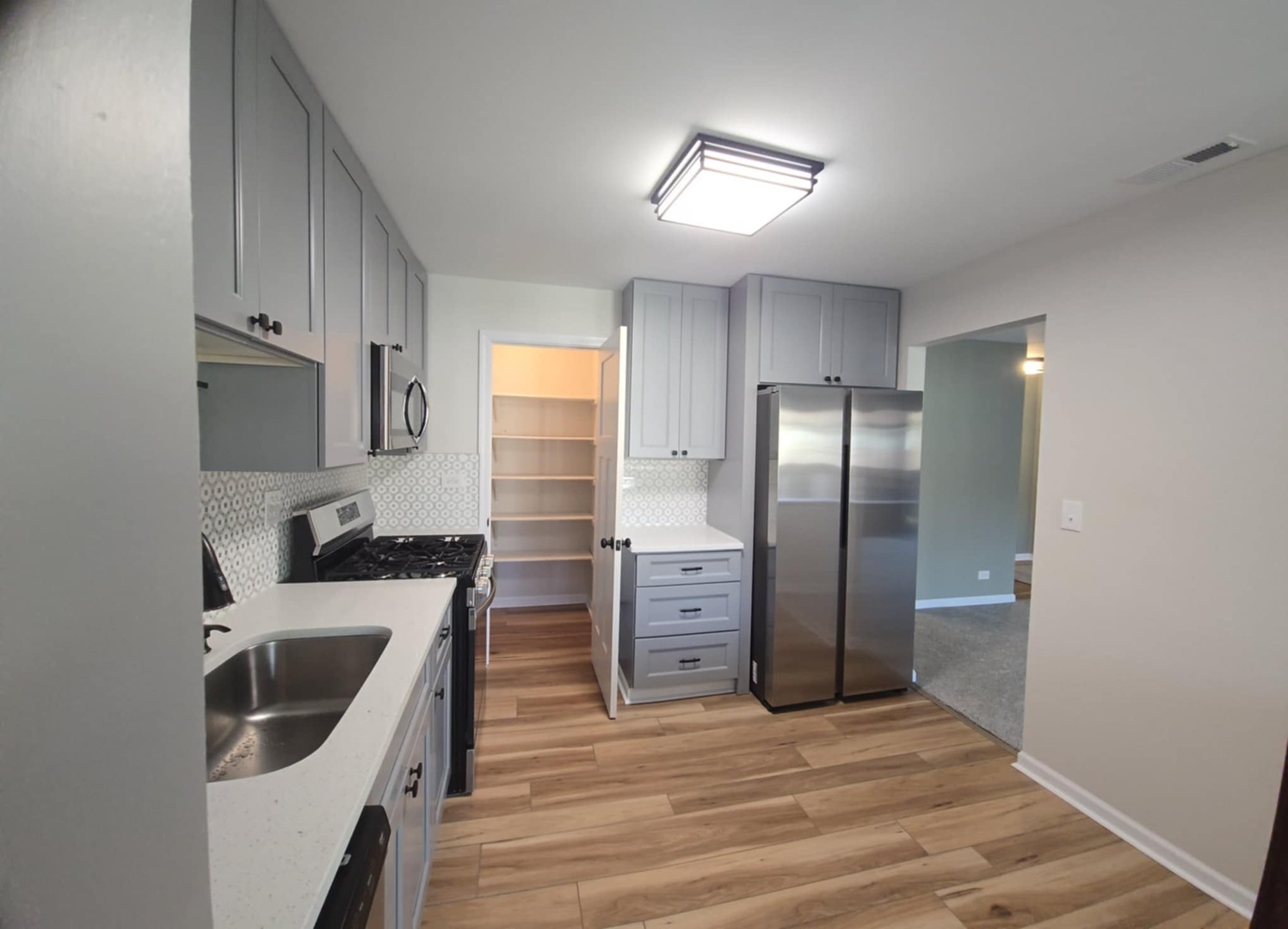 2860 Northampton Drive, Unit B2 Rolling Meadows, IL 60008 - Photo 7 of 22 a kitchen with stainless steel appliances granite countertop a refrigerator a stove and a sink with wooden floor