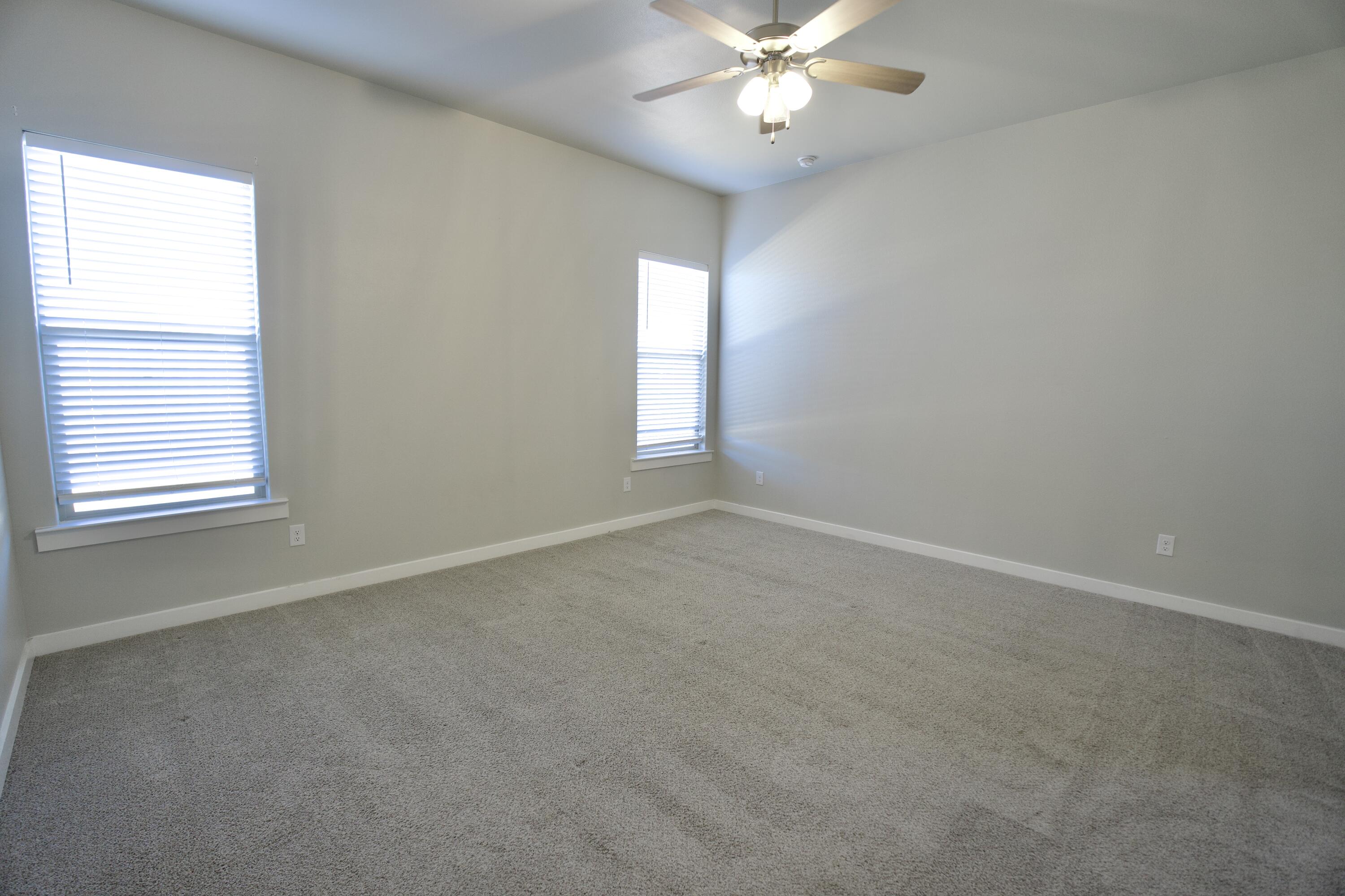 1604 137th Street Lubbock, TX 79423 - Photo 10 of 19 an empty room with windows and fan
