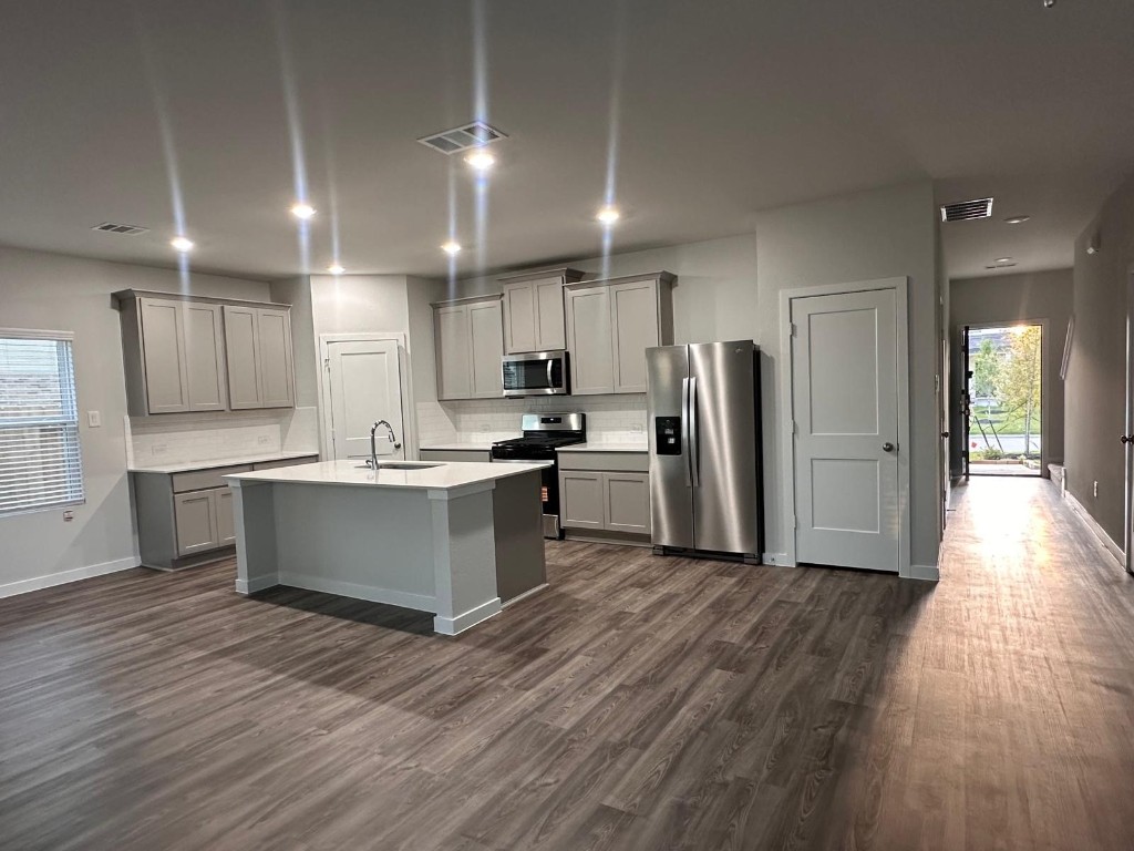 211 Brazen Forest Trail Magnolia, TX 77355 - Photo 3 of 11 a large kitchen with stainless steel appliances refrigerator a oven and wooden floors
