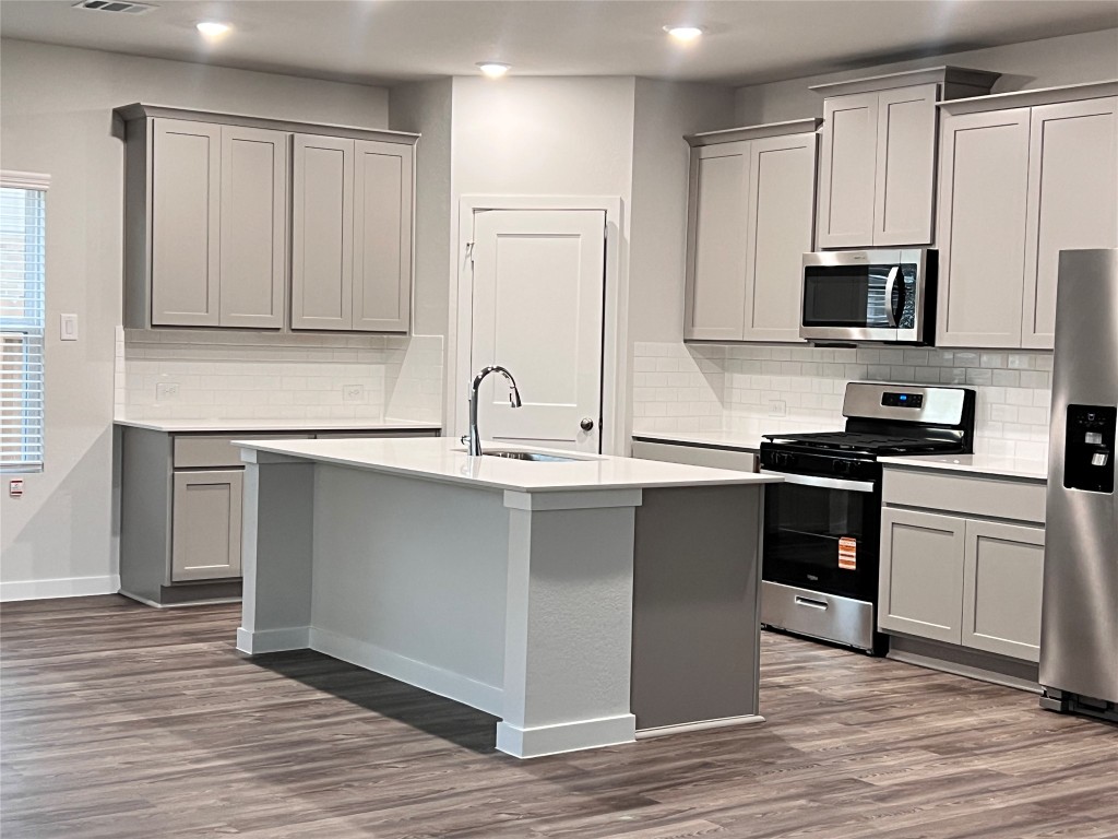 211 Brazen Forest Trail Magnolia, TX 77355 - Photo 6 of 11 a kitchen with kitchen island granite countertop a sink cabinets and stainless steel appliances