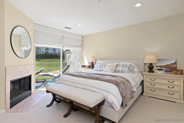 a bedroom with a bed a fireplace and a chandelier