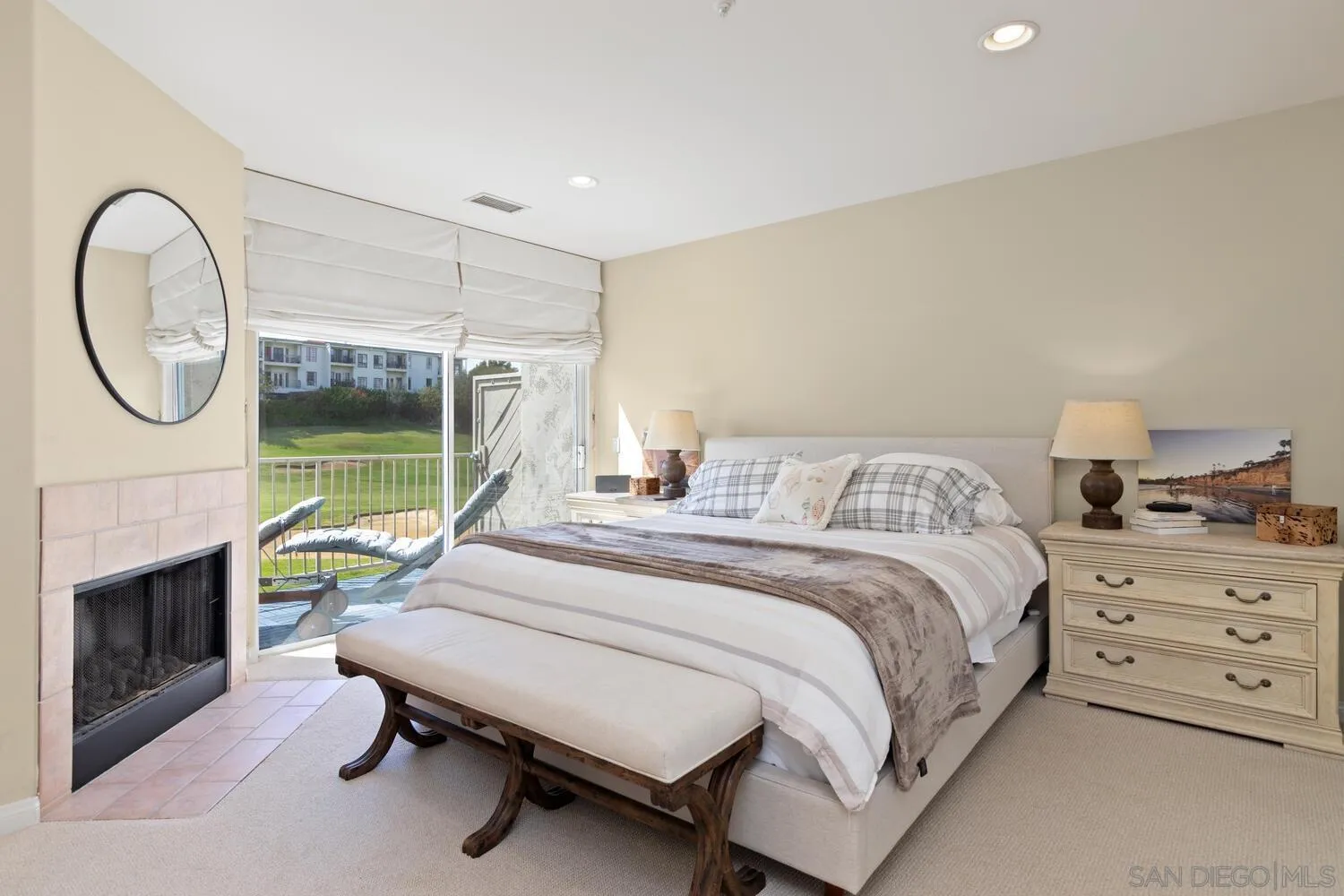 7517 Jerez Court, Unit B Carlsbad, CA 92009 - Photo 11 of 26 a bedroom with a bed a fireplace and a chandelier