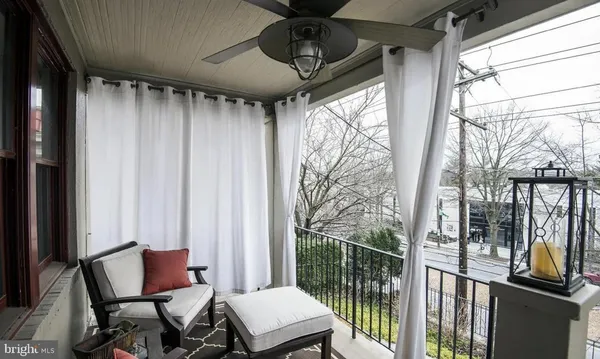 a view of a porch with furniture and floor to ceiling window