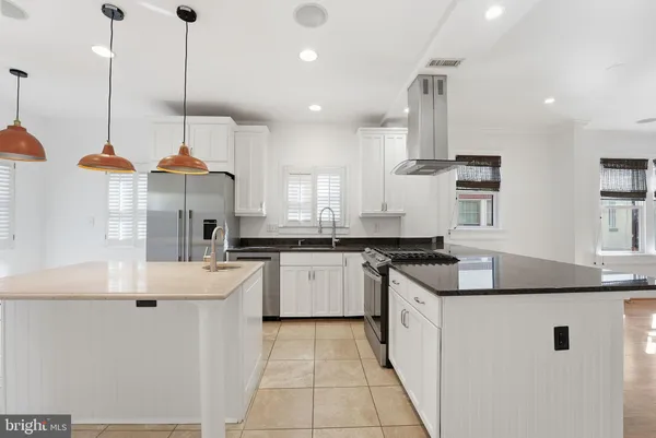 a kitchen with stainless steel appliances granite countertop a sink a stove and a wooden floor
