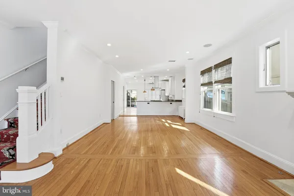 a view of empty room with wooden floor and windows