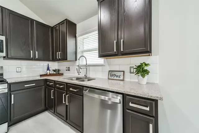 a kitchen with stainless steel appliances granite countertop a sink stove and cabinets