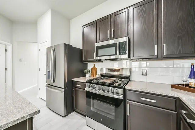 a kitchen with granite countertop stainless steel appliances and wooden cabinets