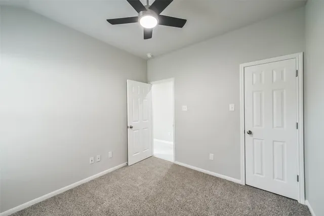 an empty room with chandelier fan