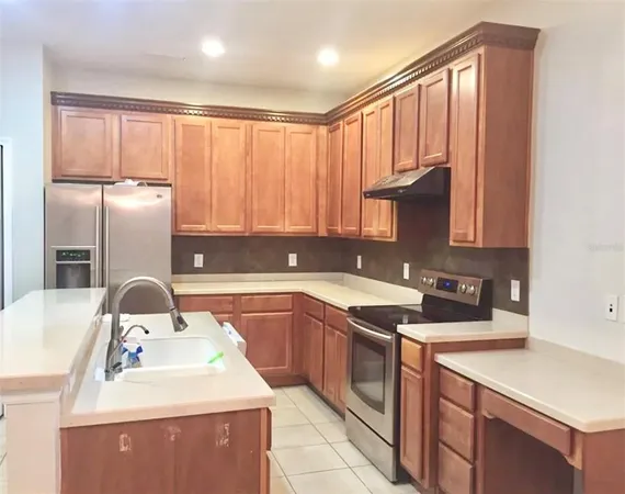 a kitchen with stainless steel appliances granite countertop a sink a stove and refrigerator