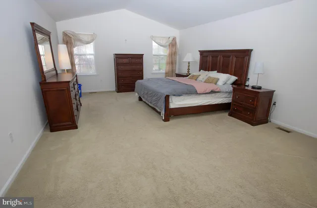 a living room with a bed furniture and a flat screen tv