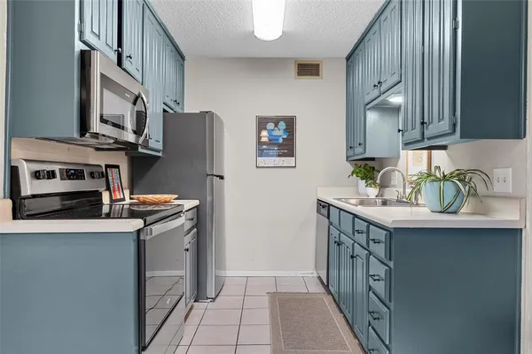 a kitchen with a sink a cabinets and wooden floor