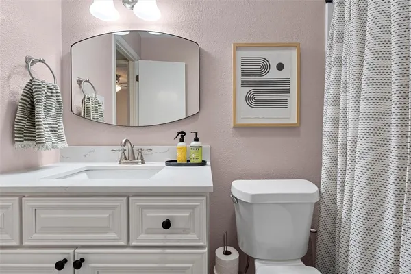 a bathroom with a toilet sink and mirror