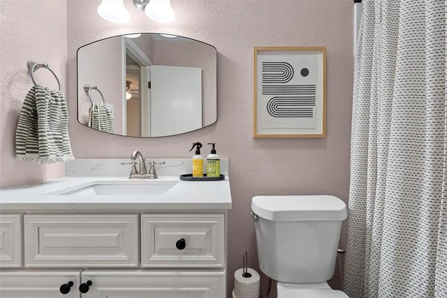 a bathroom with a toilet sink and mirror