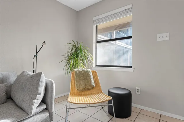 a living room with furniture a window and a potted plant