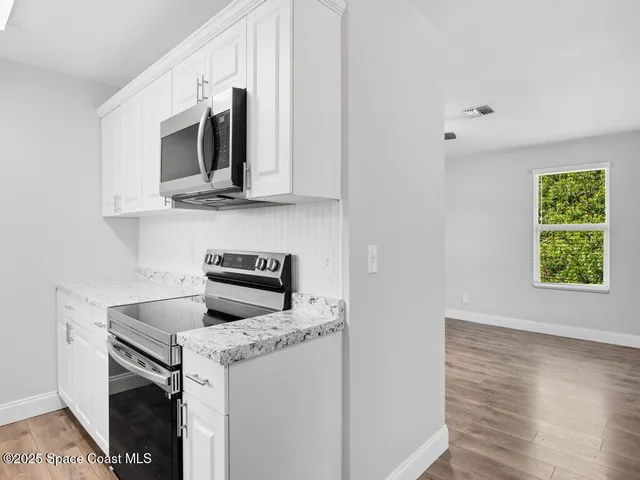 a kitchen with stainless steel appliances granite countertop a stove microwave and sink