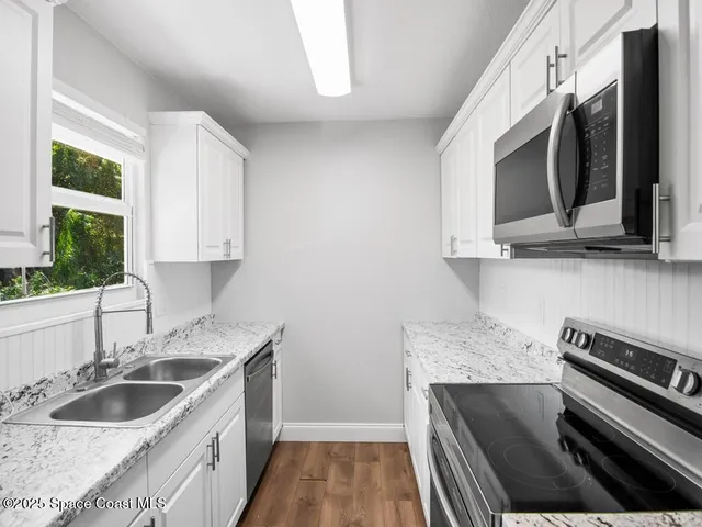 a kitchen with stainless steel appliances granite countertop a sink and a stove