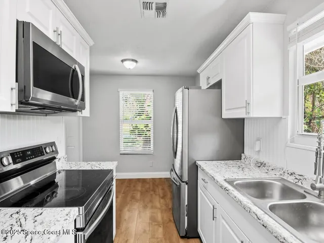 a kitchen that has a sink and a stove top oven