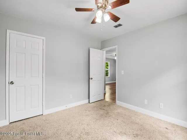 an empty room with closet and windows