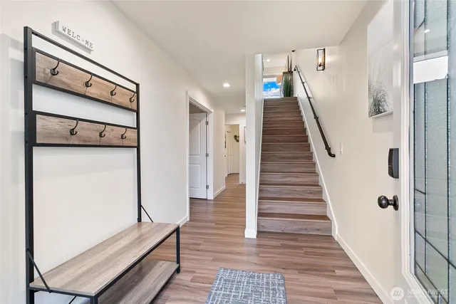 a view of a hallway with wooden floor and staircase
