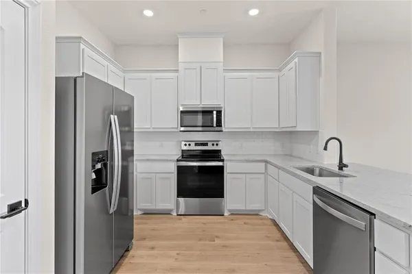 a kitchen with stainless steel appliances granite countertop a refrigerator and a sink