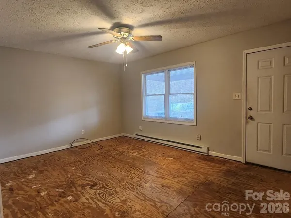 an empty room with windows and fan