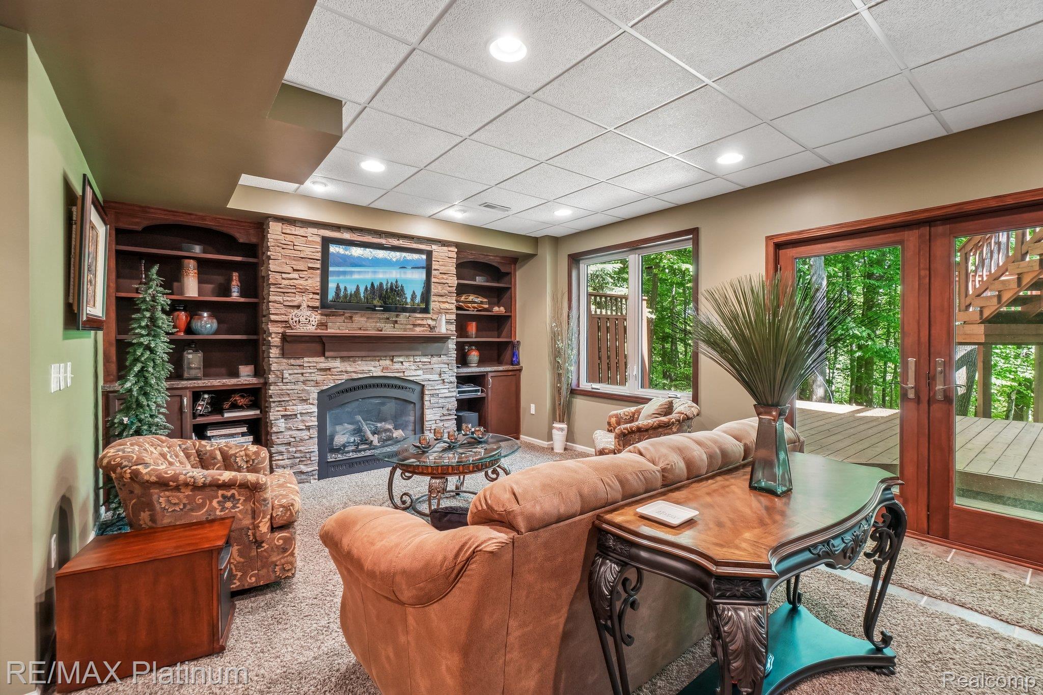 2260 Moorland's View Howell, MI 48855 - Photo 4 of 40 Lower Level Walk out with Stone-faced fireplace with a wood mantel and built-in shelving