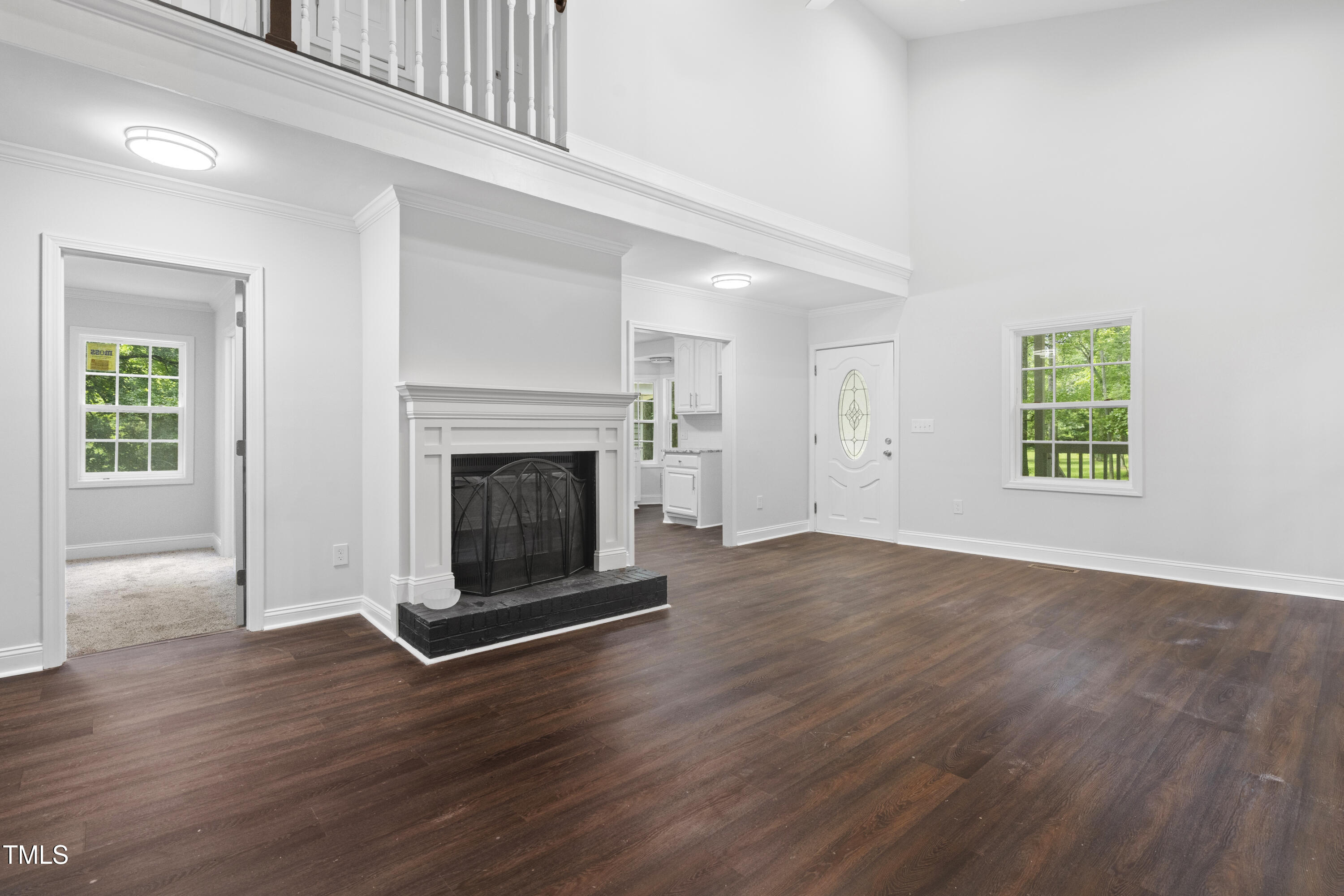 951 Walter Bright Road Sanford, NC 27330 - Photo 3 of 42 an empty room with wooden floor a fireplace and windows