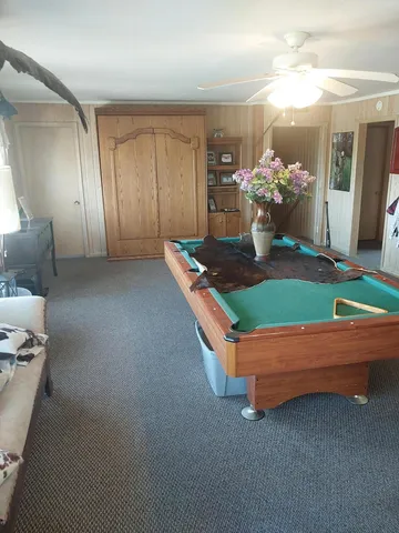 a room with pool table and windows