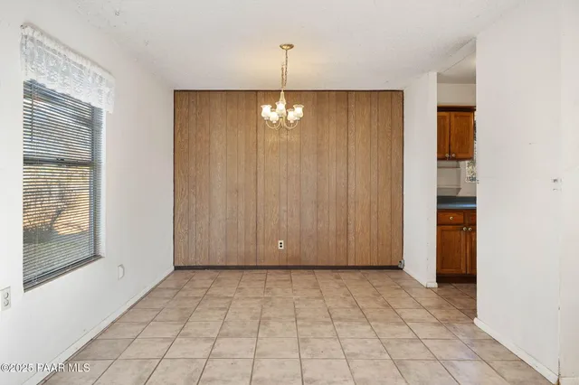 a view of a livingroom with a chandelier fan and windows