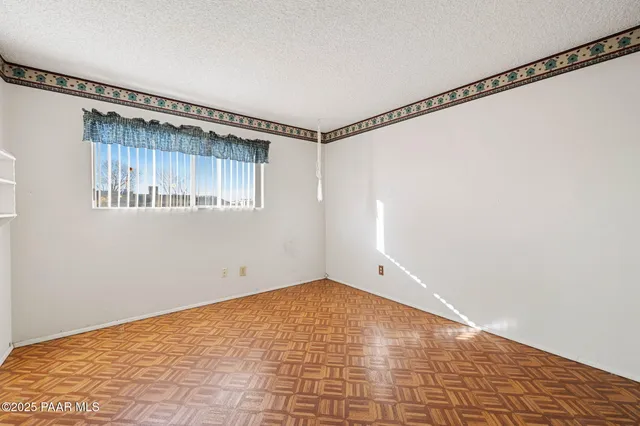 a view of a room with a wooden floor and white walls