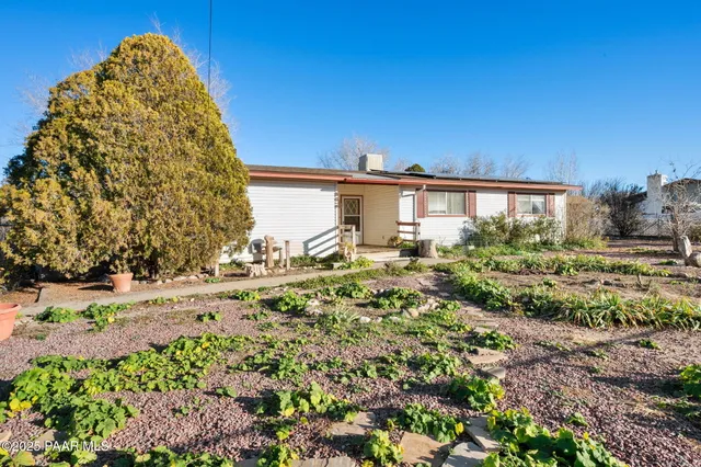 a view of a house with a yard and sitting area