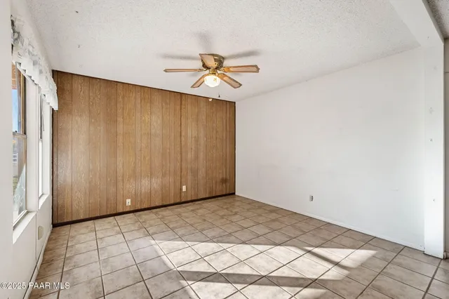 a view of a room with a ceiling fan and carpet