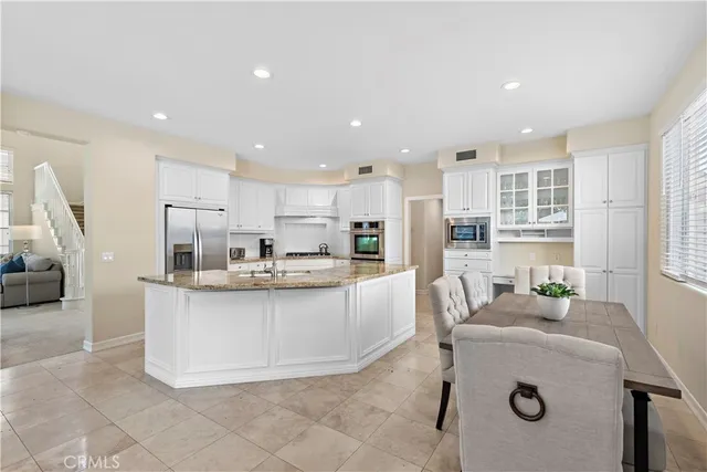 a kitchen with stainless steel appliances granite countertop a sink and a refrigerator