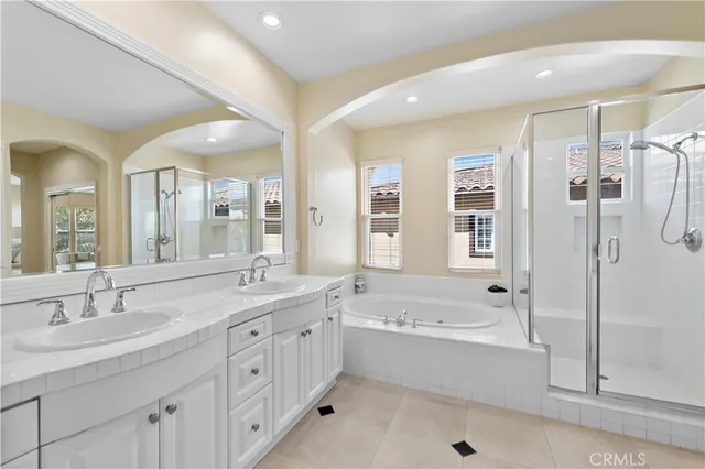 a bathroom with a granite countertop tub sink double vanity granite tub shower and mirror