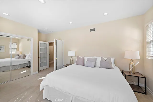 a bedroom with a large bed and a chandelier