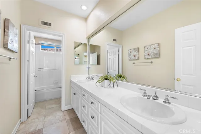 a spacious bathroom with a double vanity sink mirror and shower