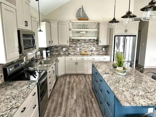 a kitchen with stainless steel appliances granite countertop a sink stove and refrigerator
