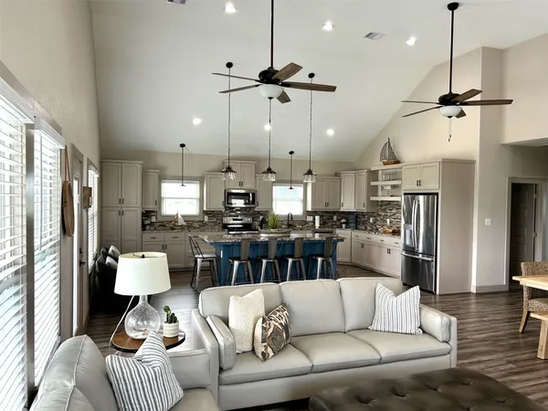 a living room with furniture kitchen view and a chandelier