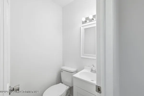 a bathroom with a toilet sink vanity and mirror