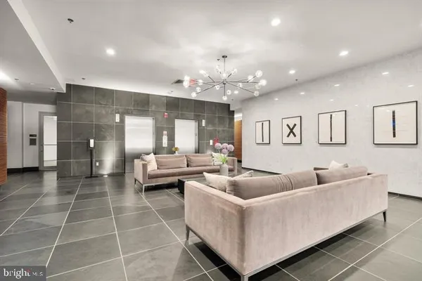 a living room with furniture and a chandelier