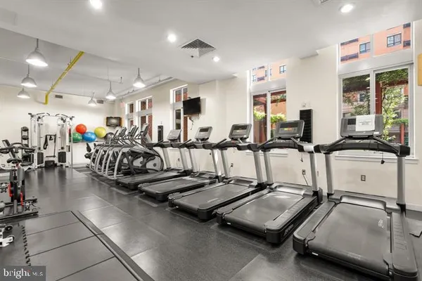a room with gym equipment and large mirror
