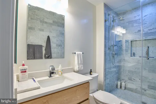 a bathroom with a sink vanity mirror and toilet