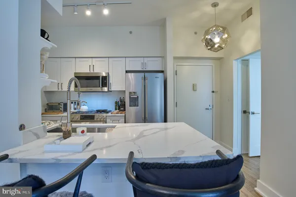 a kitchen with a refrigerator and a stove top oven