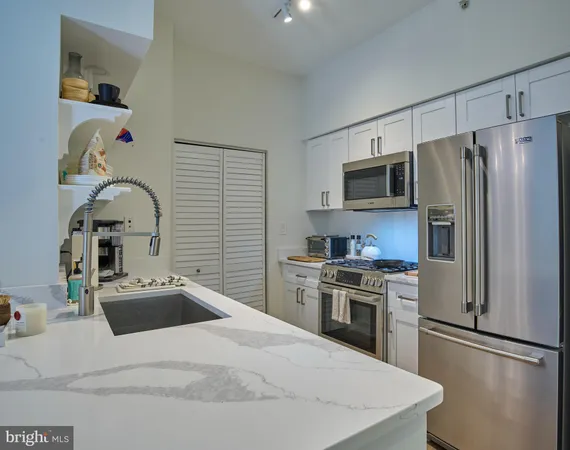 a kitchen with granite countertop a refrigerator stove and sink