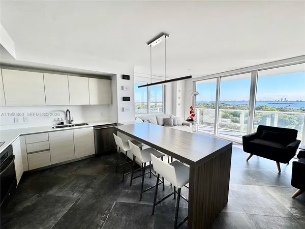 a kitchen with a stove a sink and white cabinets with wooden floor