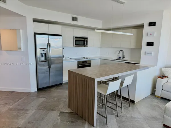 a kitchen with a refrigerator a microwave a sink and cabinets
